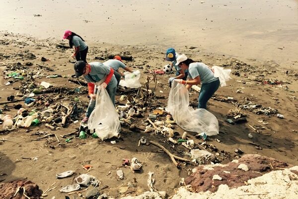 Workers collecting trash on a beach